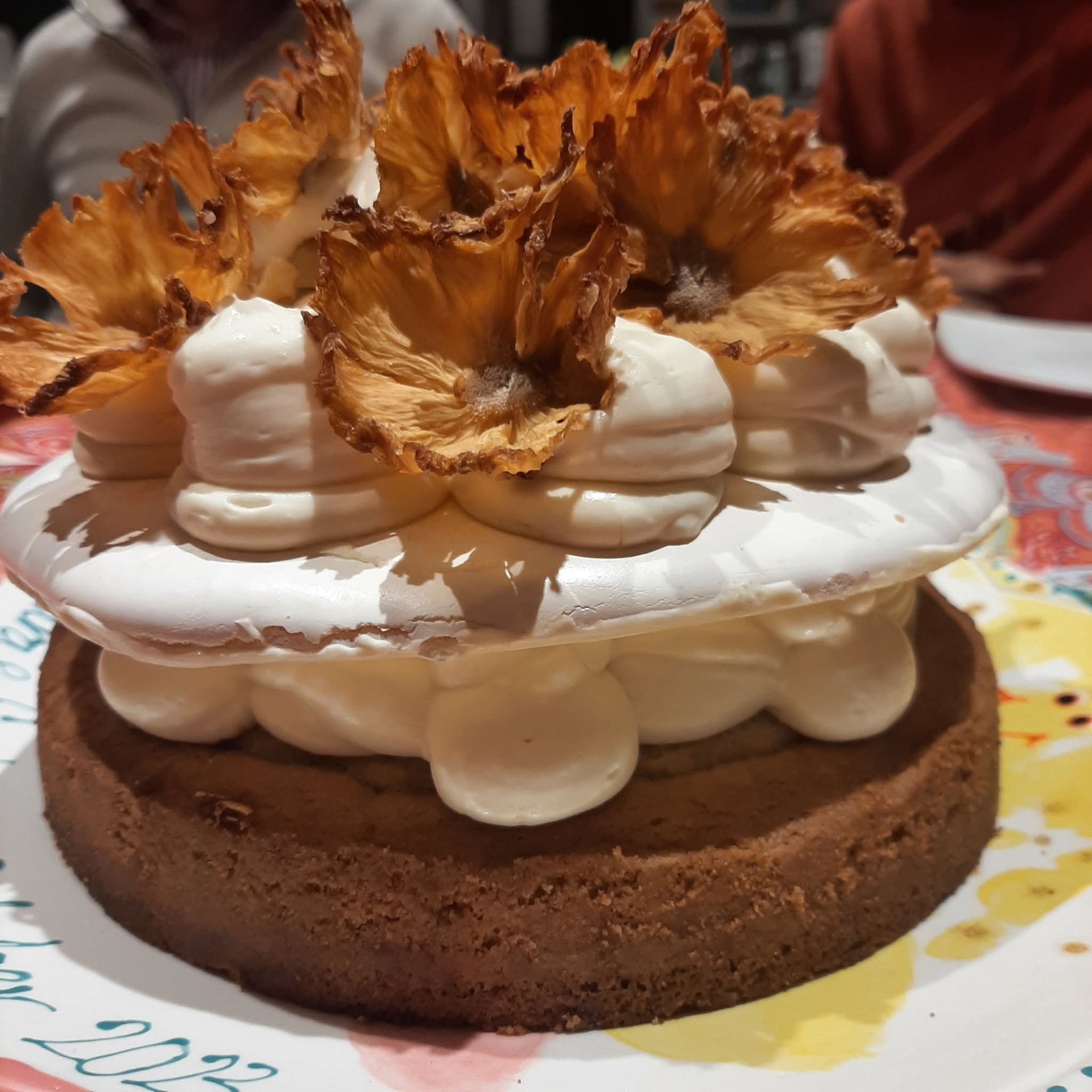 Pineapple and meringue cake decorated with dried pineapple flowers