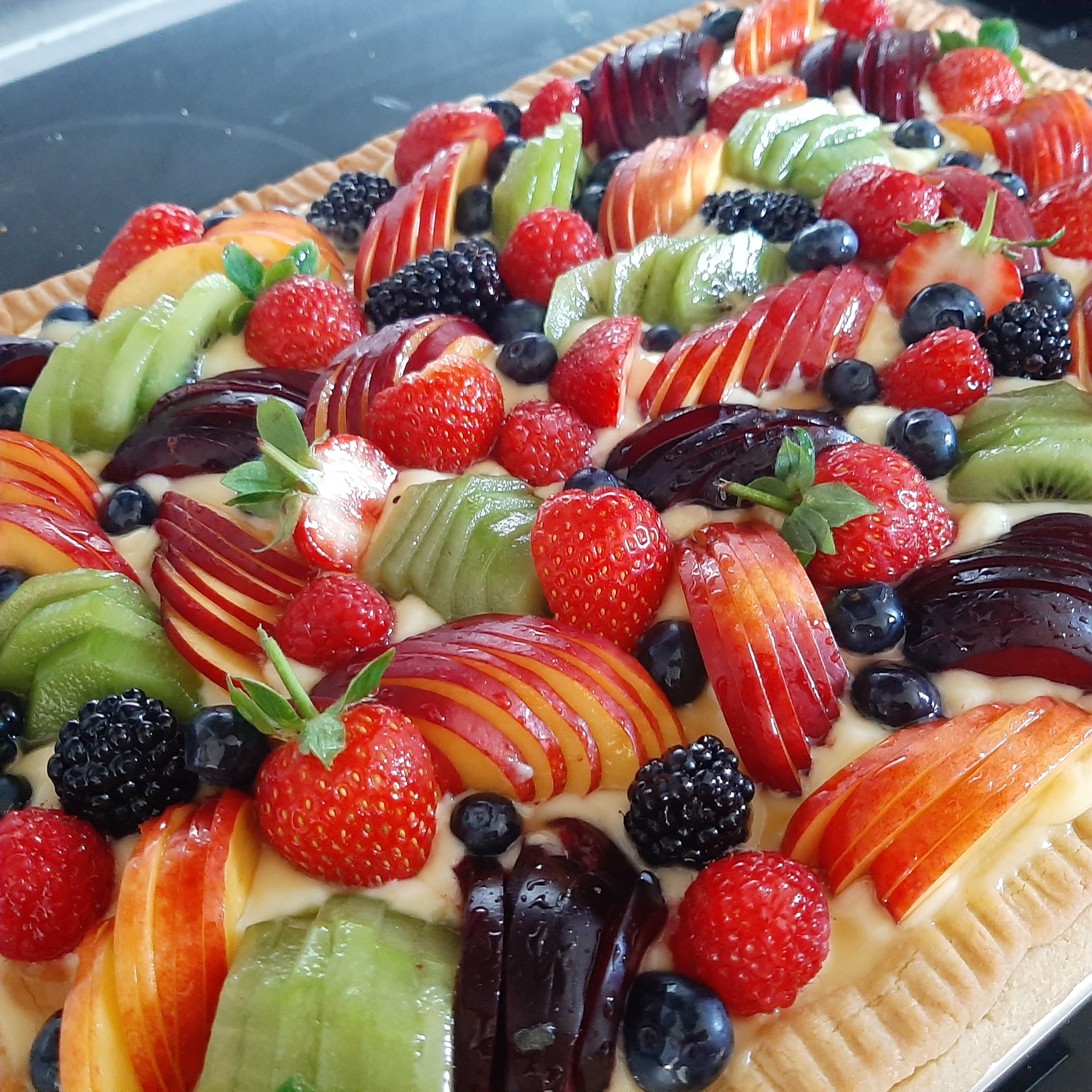 Fruit tart topped with fresh strawberries, kiwi and berries