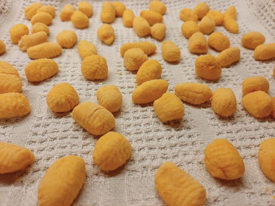 Freshly shaped pumpkin gnocchi resting on a cloth