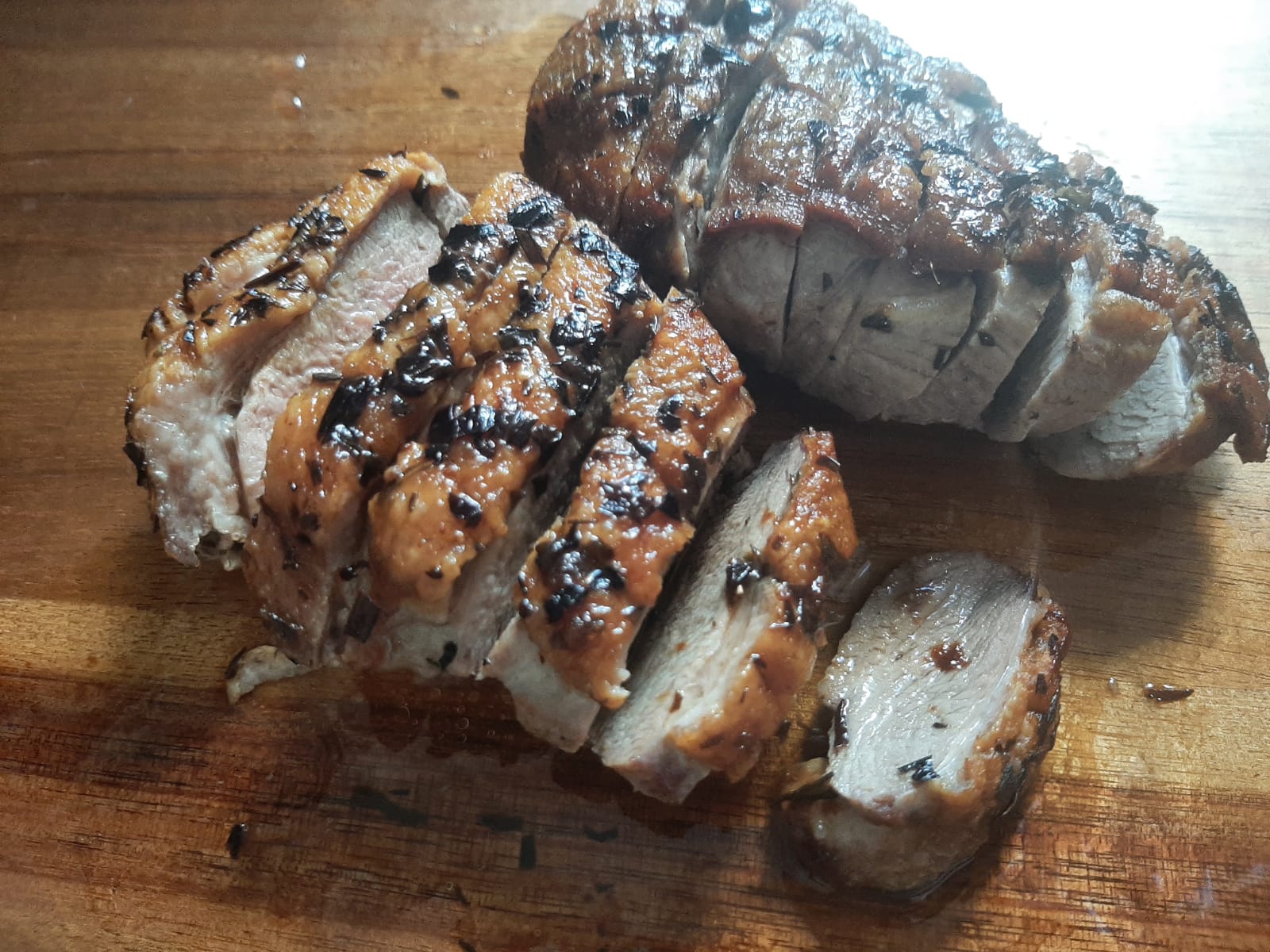 Sliced roast duck breast resting on a wooden board