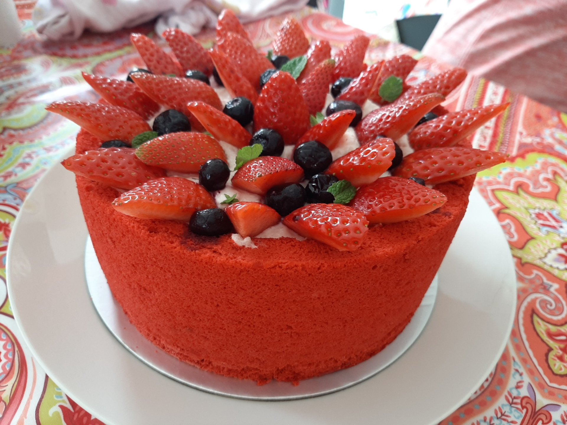 Strawberry sponge cake topped with strawberries, blueberries and mint